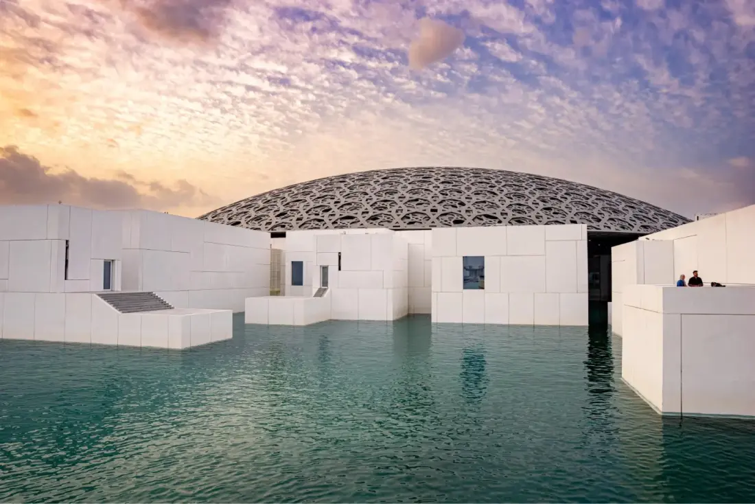 The perforated dome of Louvre Abu Dhabi sitting over the water