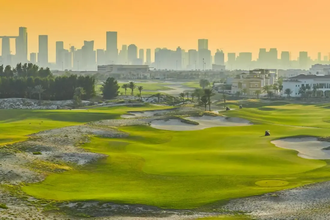 The fairways of Saadiyat Beach Golf Club with the Abu Dhabi skyline beyond